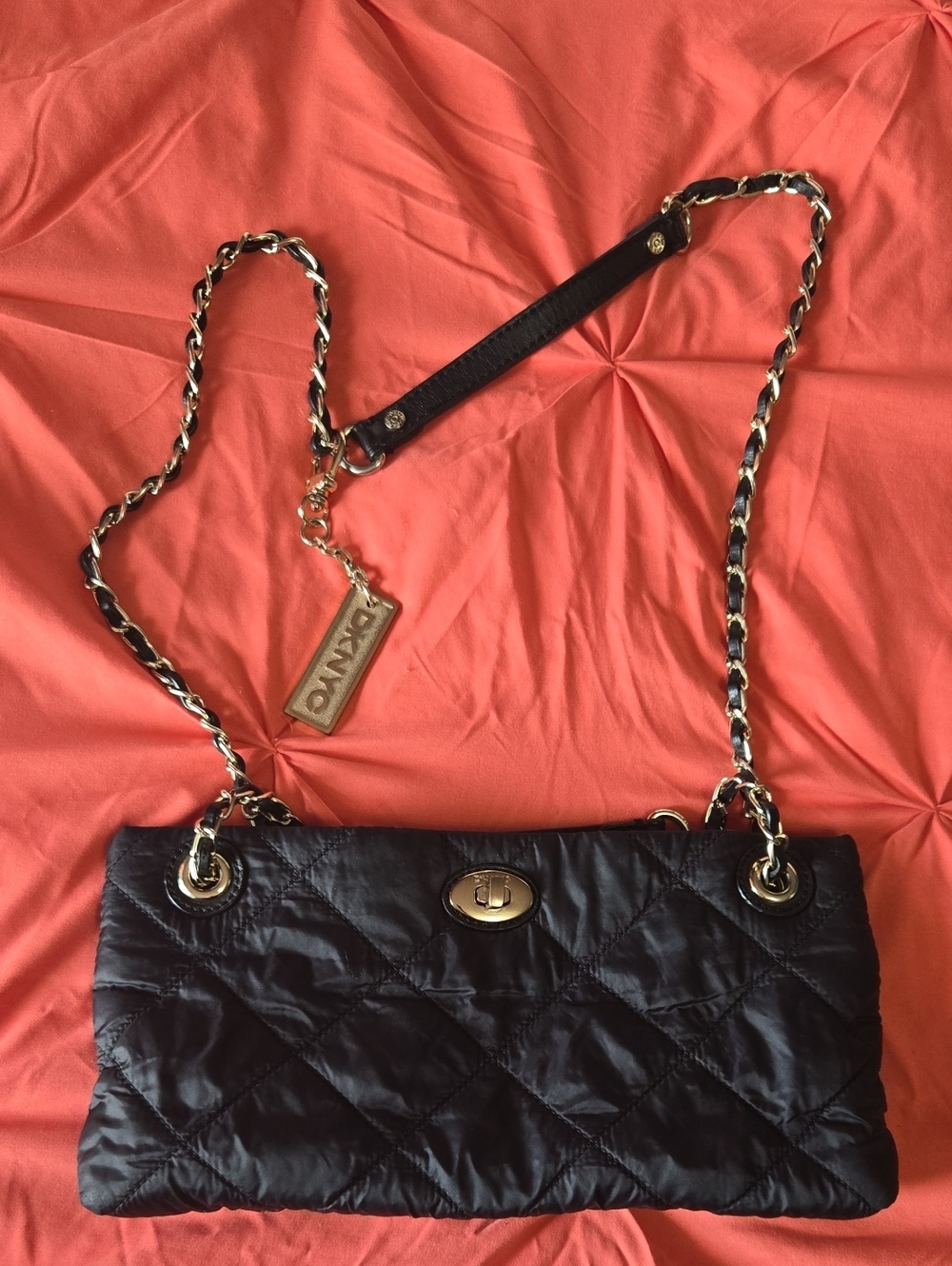 DKNYC black quilted nylon crossbody bag featuring gold-tone chain straps